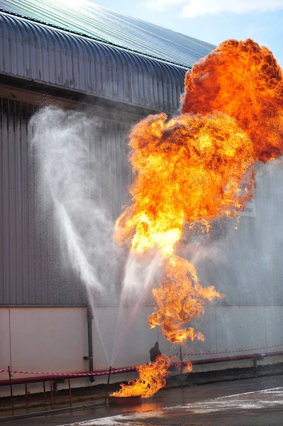 Grupo de bomberos hombre se inyectan rociar el agua para disparar acc Imágenes de stock libres de derechos