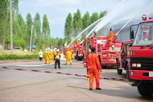 Группа пожарных человек вводят спрей воды в огонь acc — стоковое фото