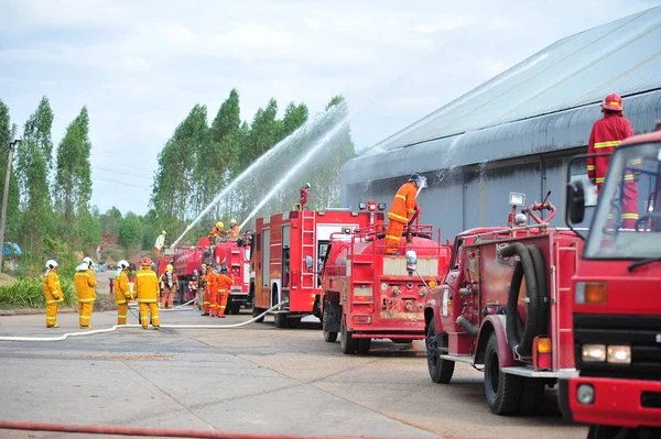 Grupo de bomberos hombre se inyectan rociar el agua para disparar acc — Foto de Stock