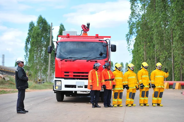 Группа пожарных человек вводят спрей воды в огонь acc — стоковое фото