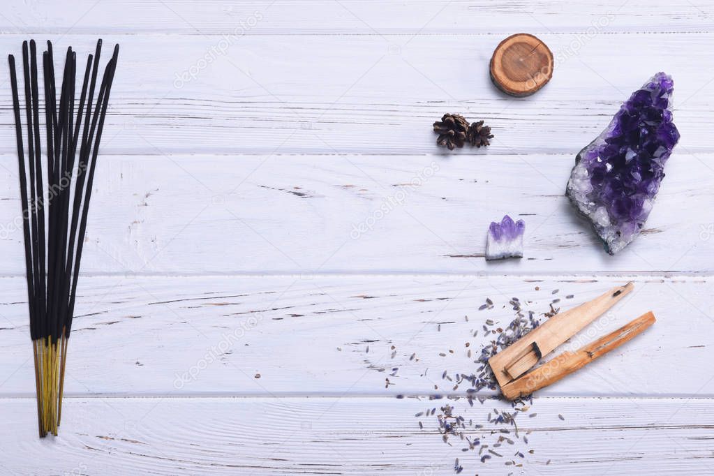 Composition of esoteric objects used for healing, meditation, relaxation and purifying. Amethyst stones, palo santo wood, Aromatic sticks on white background. 