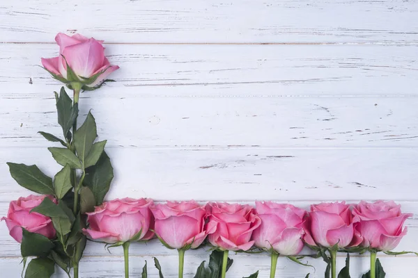 Pembe Gül çiçek kopya alanı ile beyaz ahşap zemin üzerinde. Üstten Görünüm