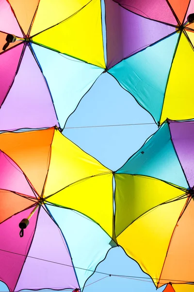 Colorful umbrellas background in blue clear sky.