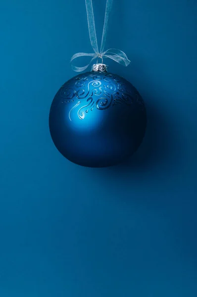 Mavi arka planda asılı duran bir Noel balosu. Boşluğu kopyala.