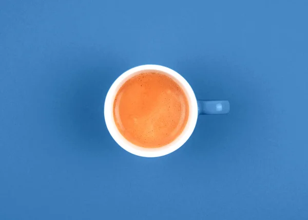 Vista superior del café recién hecho en taza de cerámica sobre fondo azul . — Foto de Stock