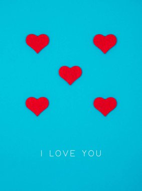 Mavi arka planda kırmızı kalplerden oluşan bayram kartı.