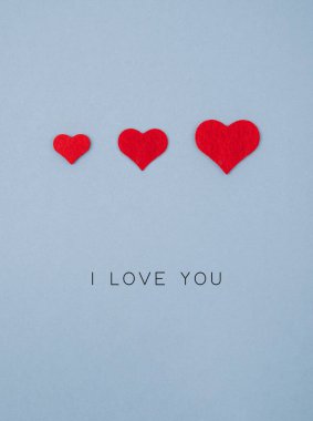 Gri arkaplanda kırmızı kalplerden oluşan bayram kartı.