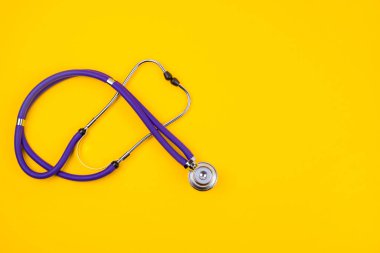 Sarı arka planda tıbbi steteskop. Boşluğu kopyala.