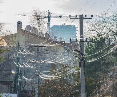 Elektrik direği ve kablolar ipek ipliğe benziyor. Şehir görünümü. 