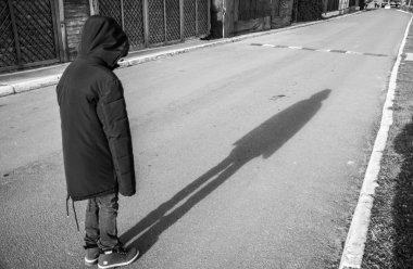 Yolda duran ceketli bir adam başını eğdi. Bir gölge. 