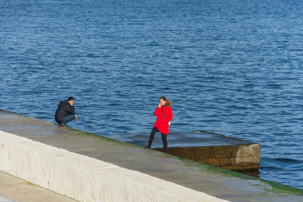 Pessoas que descansam em lajes de pedra na costa . — Fotografia de Stock