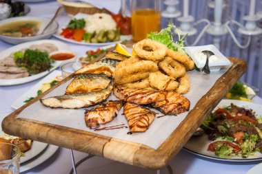 Kızarmış balık güzel bir şekilde siyah tabağa serilmiş..