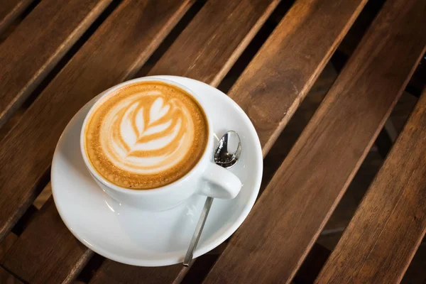 Fincan kapuçino ahşap bir masa üzerinde