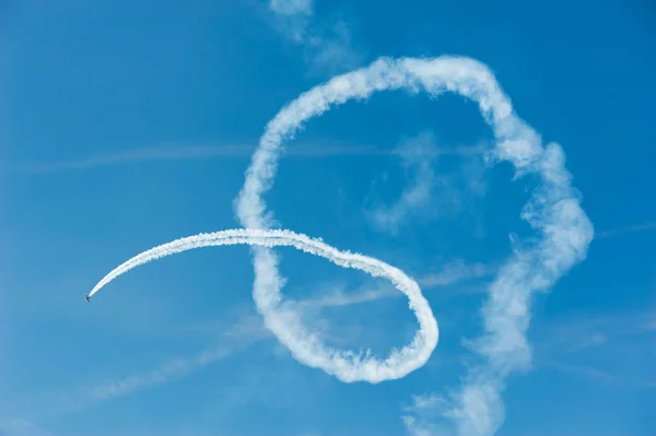 Plane acrobatics in blue sky — Stock Photo, Image