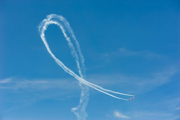 Planes in formation doing a loop with white smoke trail in blue — Stock Photo, Image