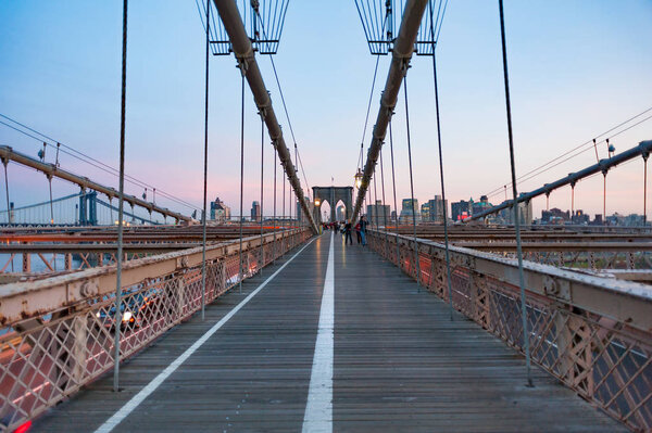 New york City, USA - Nov 14, 2011: Tourists on the Brooklyn bridge at dusk.