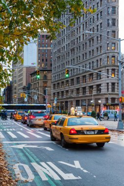 Sarı taksiler ve flatiron t bina ile bir caddede trafik