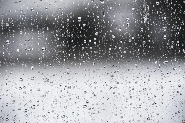 Gocce d'acqua su una finestra con sfondo bianco e nero — Foto Stock