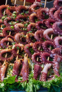 Çin pazarında şiş üstünde taze mürekkep balığı.