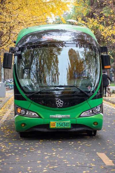 Elektromos zöld busz az utcán ősszel — Stock Fotó