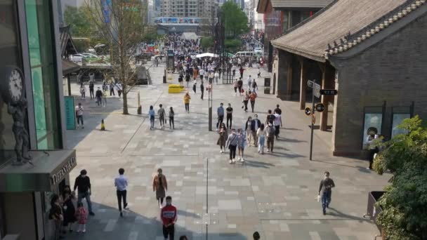 Pessoas usando máscaras de rosto andando na área comercial Taikooli em um dia ensolarado em Chengdu — Vídeo de Stock