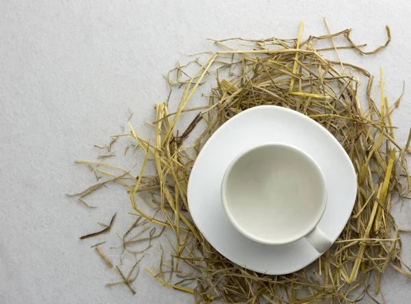 Beyaz arka planda izole edilmiş bir pipetin üzerindeki kahve fincanı..