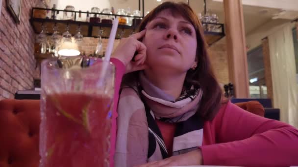 Jeune femme attrayante au café Regarder la télévision suspendue au mur — Video