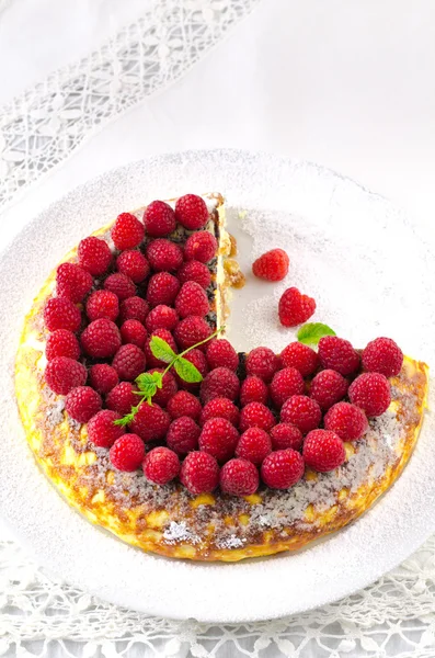 Gâteau au fromage, soufflé, mousse à la crème, dessert au pudding avec framboises fraîches et feuilles de menthe sur une assiette blanche — Photo