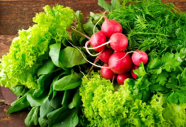 Grande grupo de vegetais orgânicos frescos, rabanete, espinafre, salada e verduras na velha mesa de madeira, close-up — Fotografia de Stock