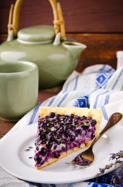 Bilberry, blueberry tart with lavender on white plate, wooden background — Stock Photo, Image