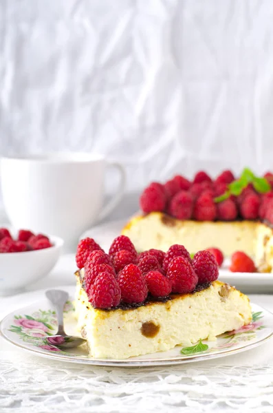 Käsekuchen, Souffle, Sahnemousse, Pudding-Dessert mit frischen Himbeeren und Minzblättern auf weißem Teller — Stockfoto