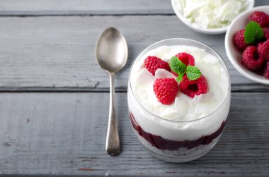 Sağlıklı kahvaltı, çöl, chia tohumu pudingi, krema, ahududu reçeli, hindistan cevizi gevreği ve taze böğürtlen.