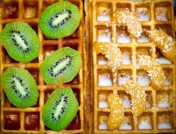 Belgian waffles with kiwi, oranges. coconut flakes and chocolate, homemade healthy breakfast, selective focus — Stock Photo, Image