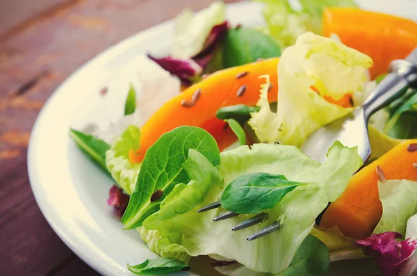 Herbstsalat mit Gemüse, Rucola, Leinsamen und geröstetem Kürbis, Kürbis auf Holzgrund — Stockfoto