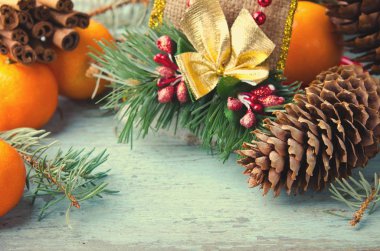 Noel, yeni yıl kompozisyon mandalina, çam ağacı ve çam kozalakları. Mavi ahşap zemin üzerine parlak tatil dekorasyon