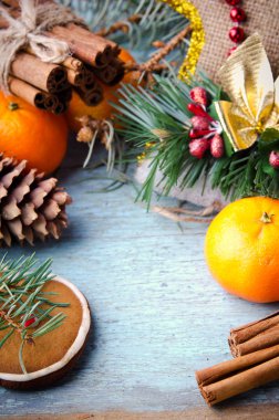 Noel, yeni yıl kompozisyon mandalina, çam ağacı, çam kozalakları, tarçın ve şeker kamışı. Mavi ahşap zemin üzerine parlak tatil dekorasyon
