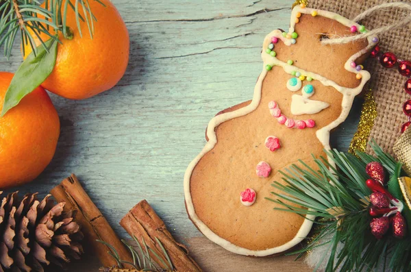 Natale, Capodanno Composizione con Uomo pan di zenzero, mandarini, abete, pigne e cannella. Decorazione di festa lucida su sfondo di legno blu — Foto Stock