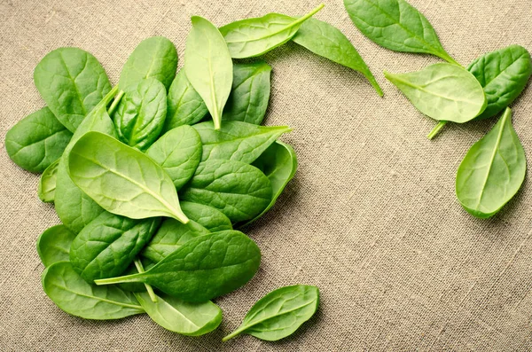 Fresh Baby spinach leaves on sackcloth background. Top view with copy space. Healthy, Ecology concept — Stock Photo, Image