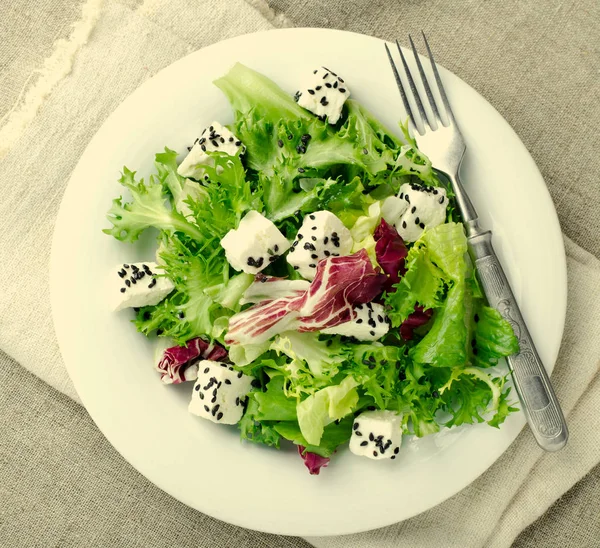 Salada verde com espinafre, frisee, arugula, radicchio, queijo feta e semente de gergelim preto em fundo de madeira azul — Fotografia de Stock
