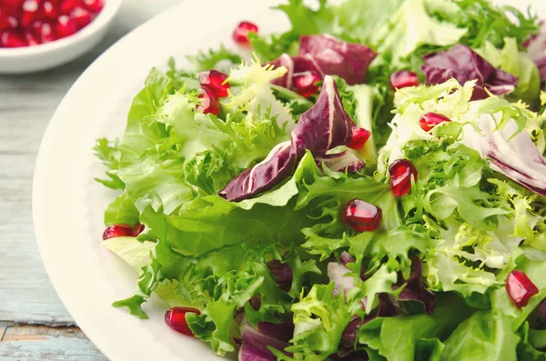 Salada verde com espinafre, frisee, arugula, radicchio e sementes de romã em fundo de madeira azul — Fotografia de Stock