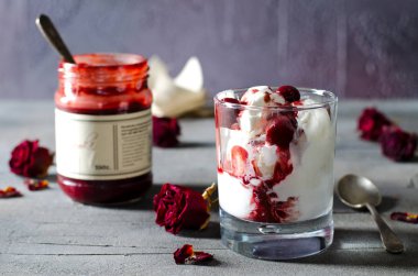 Dondurma dondurma çikolatalı topping ve koyu arka plan üzerinde kurutulmuş gül çiçekleri kiraz. Aşk, Sevgililer günü kavramı. Kopya alanı