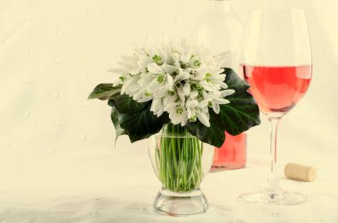 Kardelen buket, beyaz bahar çiçekleri ve açık renkli Pembe şarap. Kopya alanı