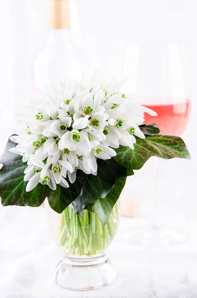 Snowdrop boeket, witte Lentebloemen en roze wijn op een lichte achtergrond. Kopiëren van ruimte — Stockfoto