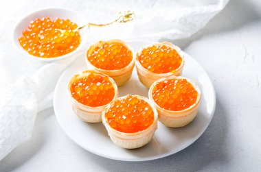 Kırmızı havyar tartlets, parlak arka plan üzerinde meze kanepeler