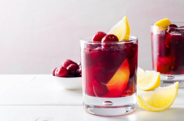 Soğuk içecek kiraz ve Beyaz ahşap zemin üzerinde bardaklarda limon ile