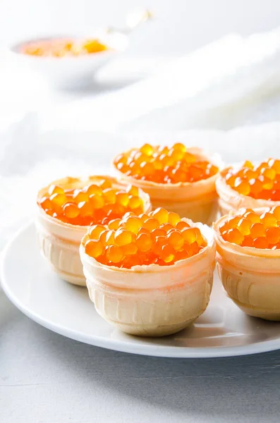 Röd kaviar tartlets, förrätt kanapéer på ljus bakgrund — Stockfoto