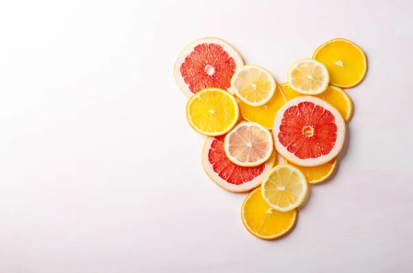 柑橘类水果的心从白色背景上的葡萄柚、 柠檬、 橙片。爱，健康，生态概念. — 图库照片