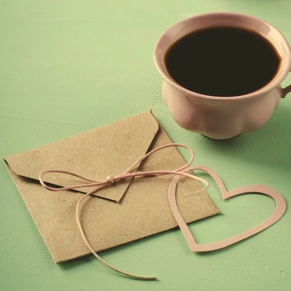 Lettera d'amore, busta e tazza di caffè rosa. Biglietto di San Valentino. Orizzontale, piatto — Foto Stock