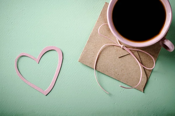 Lettera d'amore, busta e tazza di caffè rosa. Biglietto di San Valentino. Orizzontale, piatto — Foto Stock