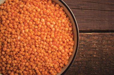 Kase ahşap arka plan üzerinde kırmızı mercimek. Yatay, tonda